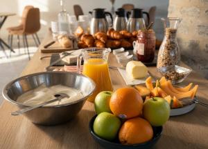 a table with a bowl of apples oranges and cheese at Château du Poët-Célard in Le Poët-Célard +10 photos