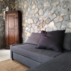 a couch in a room with a stone wall at Agritur Maso Carpenè in Rovereto