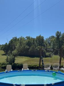 a swimming pool with chairs and a view of a field at Vila Kalkan in Šipovo +6 photos