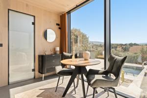 a dining room with a table and chairs and a large window at Cork Valley - Mirror Houses in Hontanar