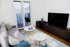 a living room with a couch and a flat screen tv at Azure Sunset in Donja Lastva