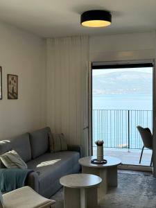 a living room with a couch and a view of the ocean at Azure Sunset in Donja Lastva