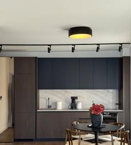 a kitchen with black cabinets and a table with a vase on it at Azure Sunset in Donja Lastva