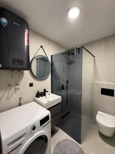a bathroom with a washing machine and a sink at Azure Sunset in Donja Lastva +6 photos