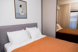 a hotel room with a bed and a mirror at Azure Sunset in Donja Lastva