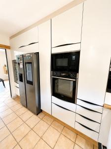a kitchen with a refrigerator and a microwave at Le Petit Paradis Lescurien in Lescure-dʼAlbigeois +7 photos