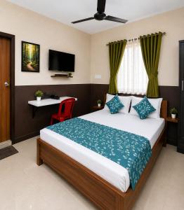 a bedroom with a bed with a television and a red chair at Hotel Shepherds in Bīdar