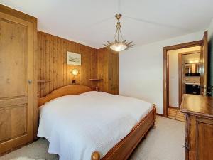 a bedroom with a bed and a chandelier at Tayannes 222 in Verbier