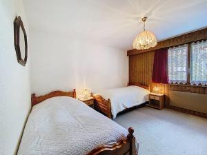 a bedroom with two beds and a chandelier at Tayannes 222 in Verbier