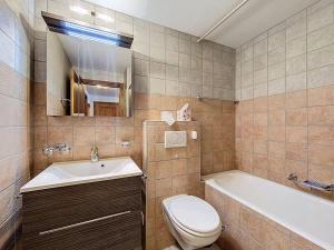 a bathroom with a toilet and a sink and a tub at Tayannes 222 in Verbier