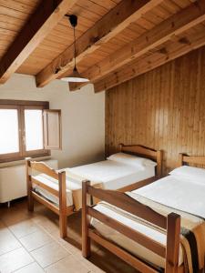 two beds in a room with wooden walls at Alberg rural torre del baró in Sant Llorenç de Morunys