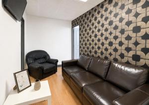 a living room with a leather couch and a chair at Grand T4 Compiègne in Compiègne