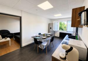 a living room with a table and chairs in a room at Grand T4 Compiègne in Compiègne