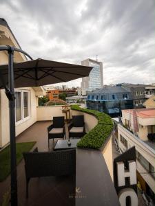 a balcony with chairs and a table and an umbrella at Hotel Kika in Prishtinë