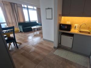 a kitchen and living room with a sink and a couch at Sunshine Suites Times square KL in Kuala Lumpur