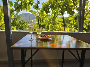 Ein Tisch mit zwei Gläsern Wein und einer Schale Obst in der Unterkunft Garden Room by the Vineyard Salamis in Aiándion