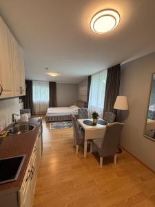a kitchen and living room with a table and a bed at Pas Kastyti in Palanga