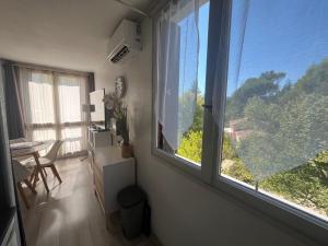 a room with two windows and a desk and a table at Mon Paradis en Provence B29 in Gréoux-les-Bains
