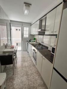 a kitchen with white cabinets and a table and a dining room at Bacarola in Los Mártires