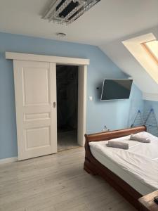 a bedroom with a bed and a tv on the wall at W Dolinie in Małkowice