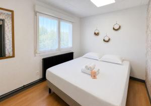 a white bedroom with a bed with a cross on it at Grand T4 Compiègne in Compiègne