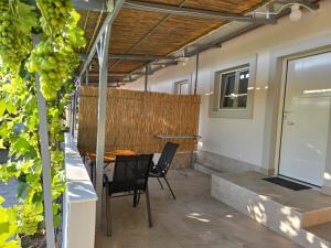 eine Terrasse mit Tisch und Stühlen und einem Zaun in der Unterkunft Garden Room by the Vineyard Salamis in Aiándion