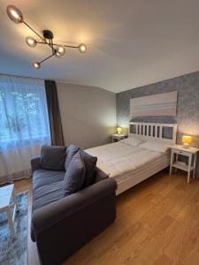 a bedroom with a large bed and a couch at Pas Kastyti in Palanga