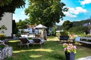 a yard with two chairs and a table and benches at Hotel Kaiserhof in Anif