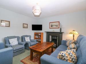 a living room with blue couches and a fireplace at The Lock House in Gloucester