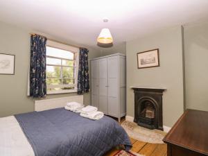 a bedroom with a bed and a fireplace at The Lock House in Gloucester