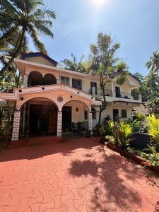 a large house with a driveway in front of it at Jes Guest House in Majorda