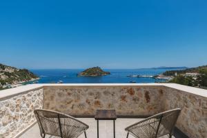 two chairs and a table on a balcony overlooking the ocean at Apaggio Luxury Villa - Private Pool & Stunning Sea Views, by ZanteWize in Agios Nikolaos