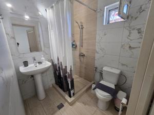 ein Badezimmer mit Dusche, Toilette und Waschbecken in der Unterkunft Garden Room by the Vineyard Salamis in Aiándion