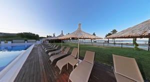 a row of chairs and umbrellas next to a pool at Aloria Garden Hotel in Erdek