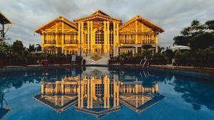 a large building with a pool in front of it at YKC Hotels & Resorts in Bāghdogra