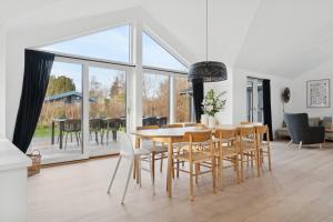 a dining room with a table and chairs and a large window at Modern Holiday Home With Annex And 10 Beds in Rude