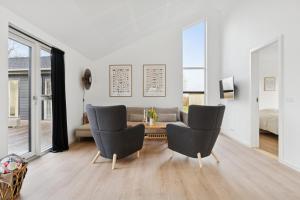 a living room with a couch and a table and chairs at Modern Holiday Home With Annex And 10 Beds in Rude