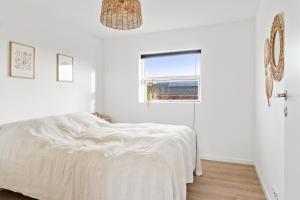 a white bedroom with a bed and a window at Modern Holiday Home With Annex And 10 Beds in Rude
