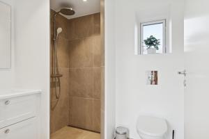 a bathroom with a shower and a toilet at Modern Holiday Home With Annex And 10 Beds in Rude +24 photos