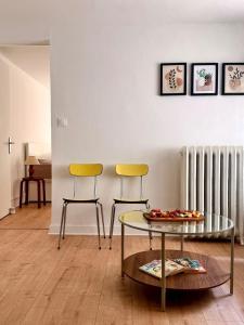 a living room with two chairs and a glass table at Grand T2 neuf Chartrons in Bordeaux