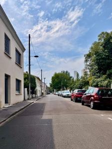 a street with cars parked on the side of the road at Grand T2 neuf Chartrons in Bordeaux