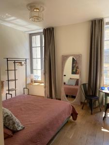a bedroom with a bed and a large mirror at The Purple Courtyard in Beaune