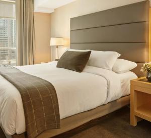 a bedroom with a large white bed and a window at Tharusha Hotel in Udawalawe