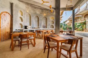 a dining room with wooden tables and chairs at Casa Rodi Zanzibar in Jambiani
