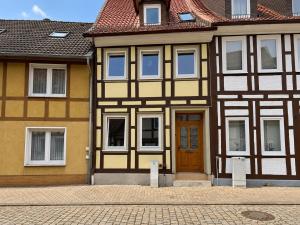 a yellow and white building with a brown door at Workers House in Bockenem