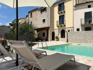a pair of chairs and an umbrella next to a swimming pool at Casa Ripa in Ripabottoni