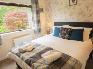 a bedroom with a large bed with towels on it at Kinloch Lodge in Drumnadrochit