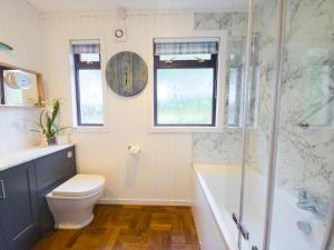 a bathroom with a toilet and a glass shower at Kinloch Lodge in Drumnadrochit +43 photos