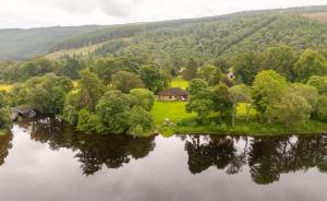 an aerial view of a house on an island in a lake at Kinloch Lodge in Drumnadrochit