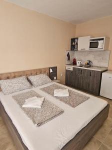 a bedroom with two beds with towels on them at Апартаменти Кастро2-Castro Apartments2 in Tsarevo